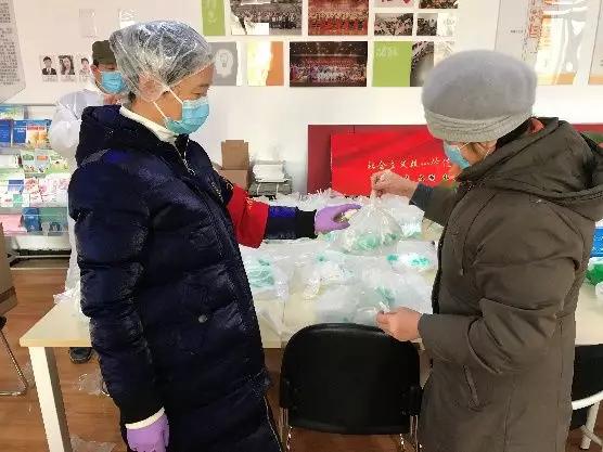 为楼栋分发口罩,并为包装袋消毒
